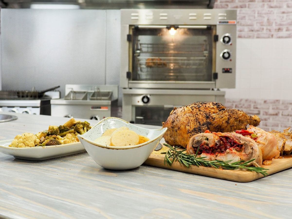 Roast and sides plated in front of an Anvil rotisserie oven