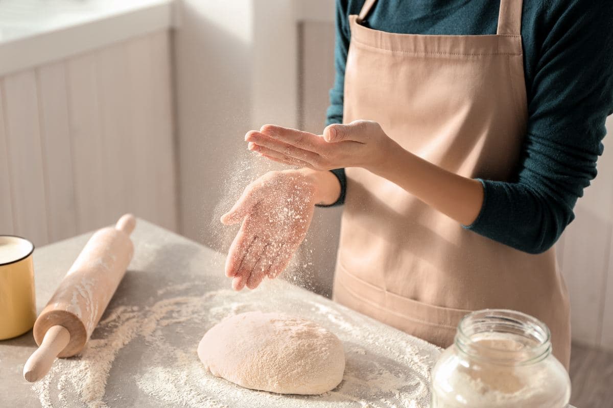 Baker rolling out dough with a rolling pin