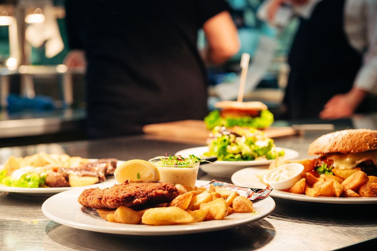 Kitchen team plating meals at the pass