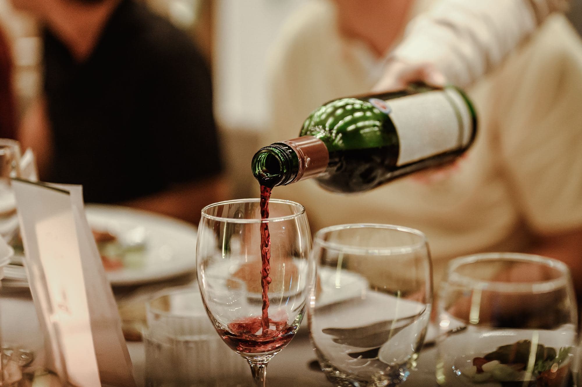 Wine poured at a restaurant table set with cutlery