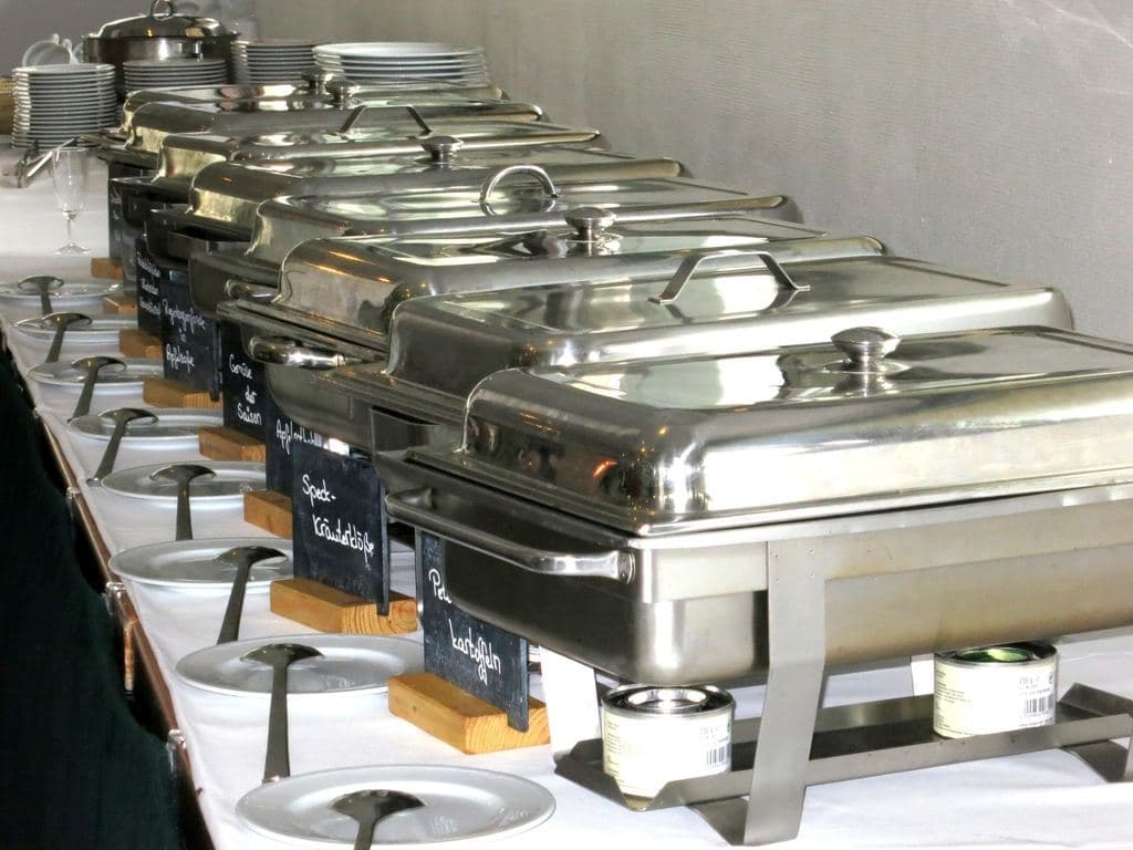 A row of chafing dishes on a hotel buffet