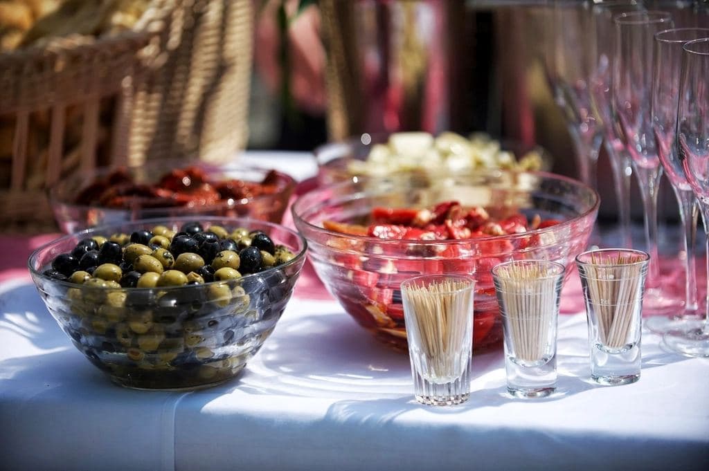 Buffet table with bowls of olives and glassware