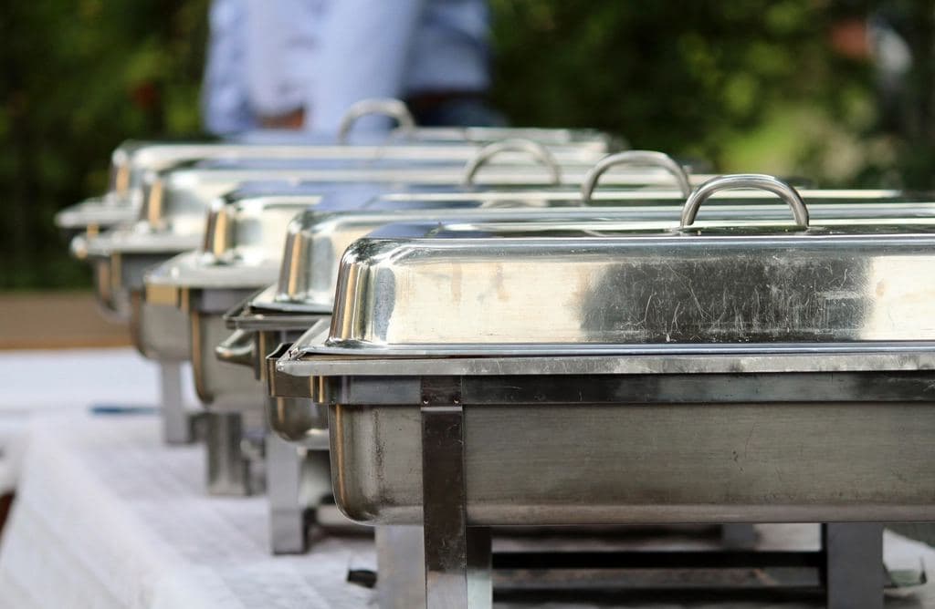 Stainless chafing dishes lined up for service