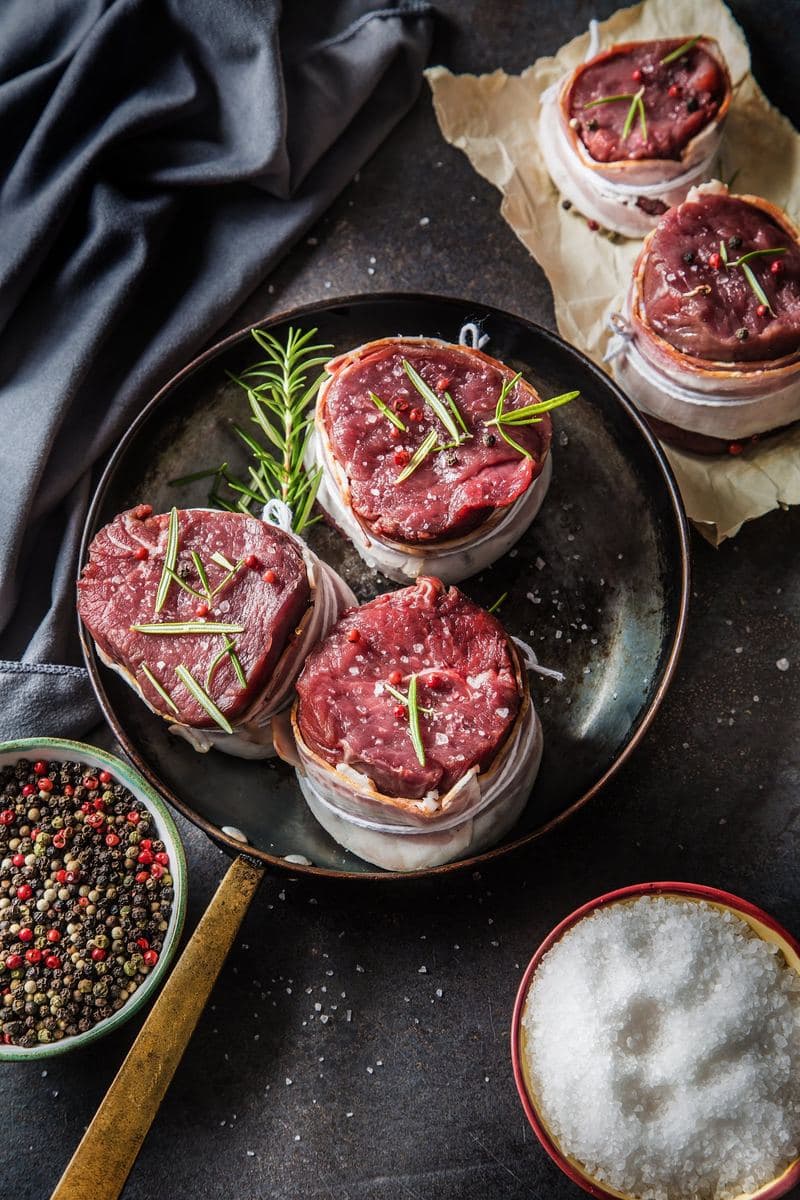 Raw fillet steaks seasoned on a board