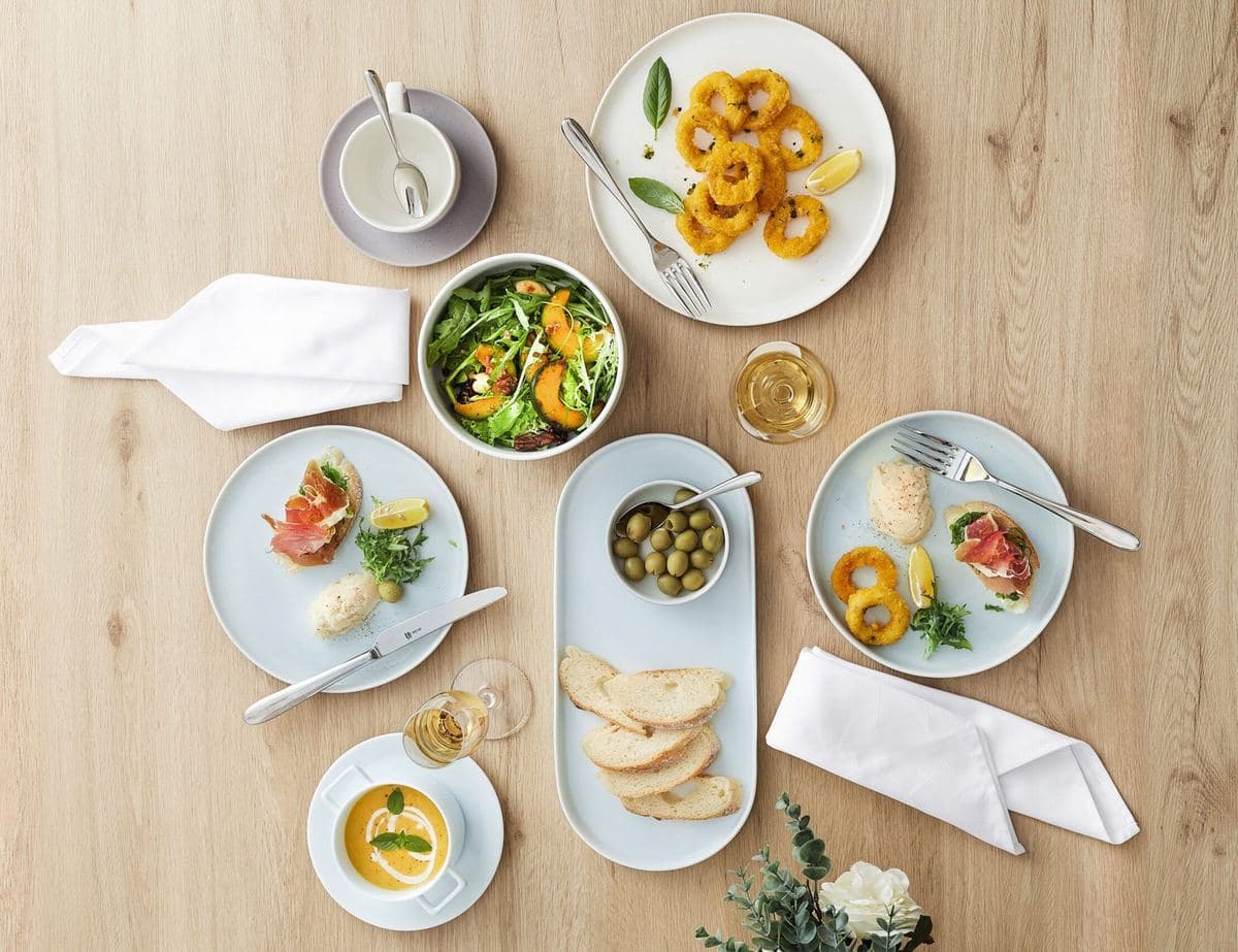 A bright table set with Luzerne porcelain