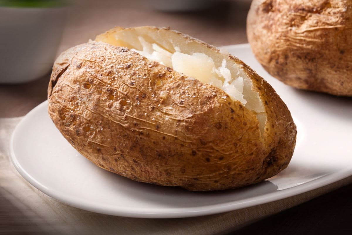 A baked potato split open on a plate