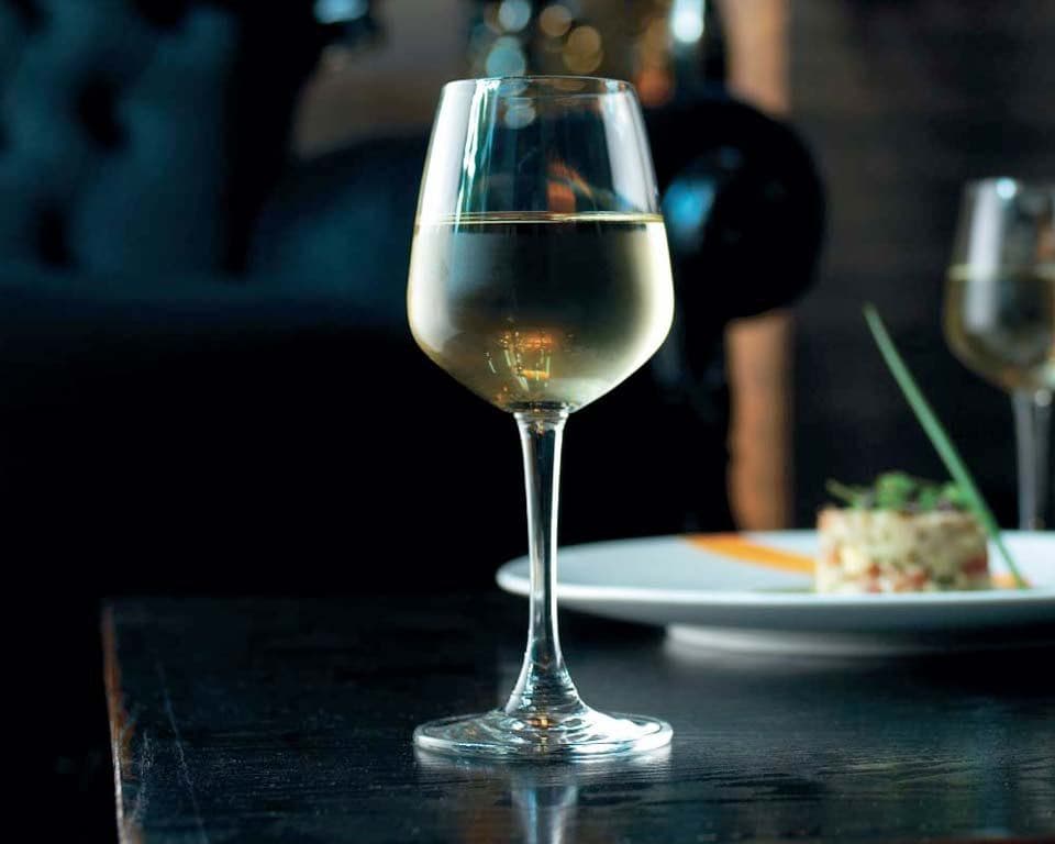 Ocean white wine glass on a restaurant table at night