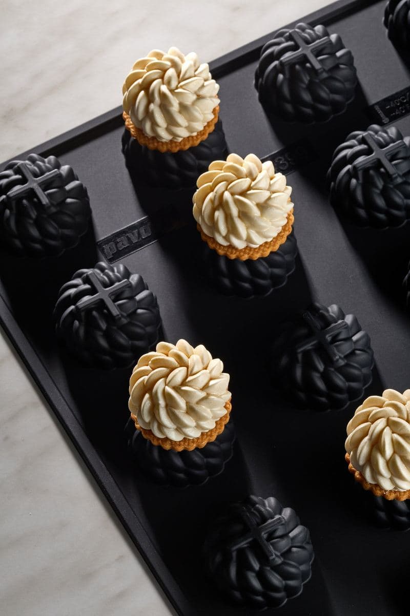 Cream-topped tartlets set on a black Pavoni silicone mould