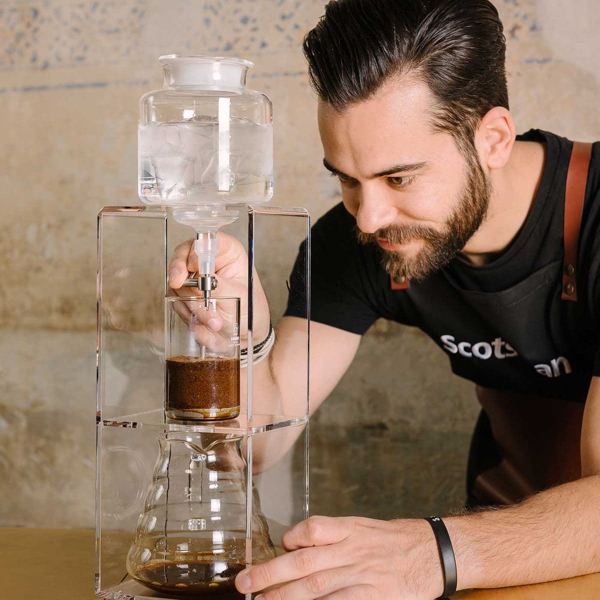 Barista with a cold-drip coffee tower and Scotsman ice