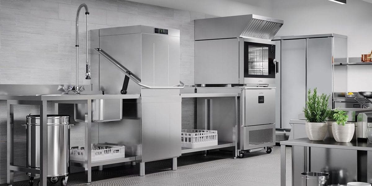 Smeg Professional hood-type dishwasher and racks in a scullery