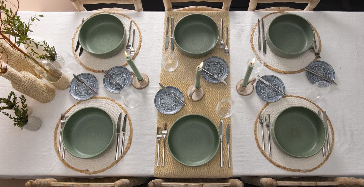 Long table laid with Sola cutlery and green plates
