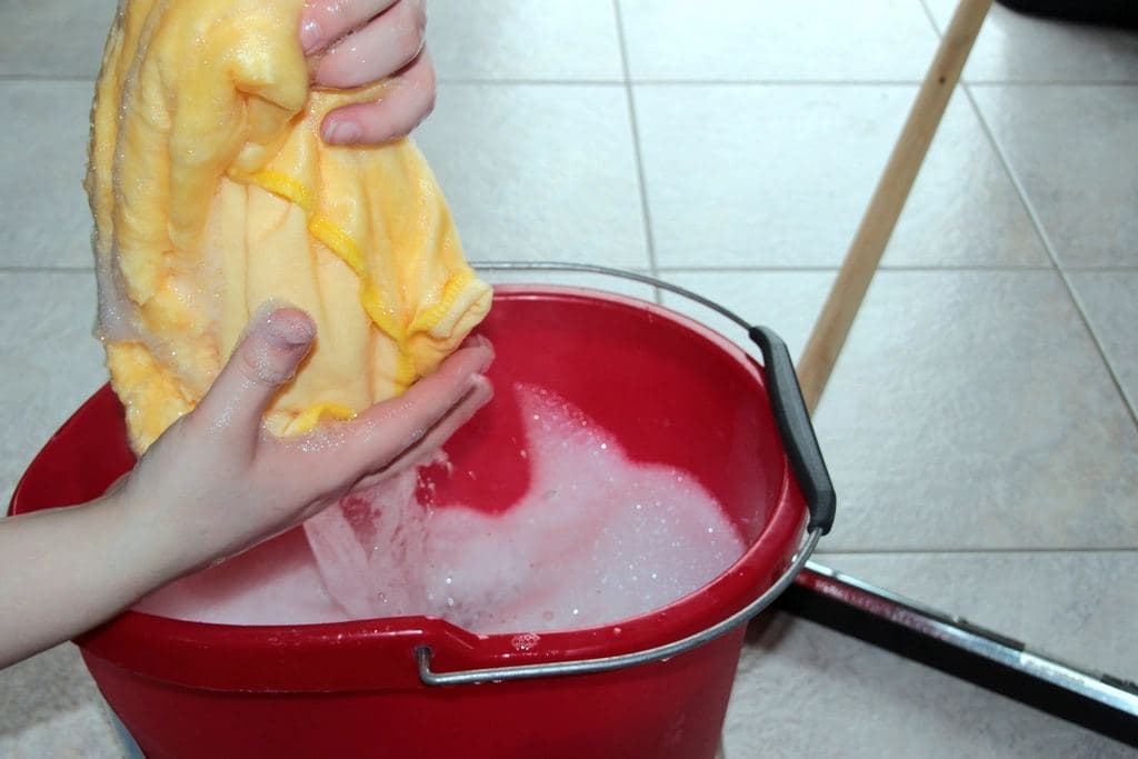 Cloth wrung out over a red bucket