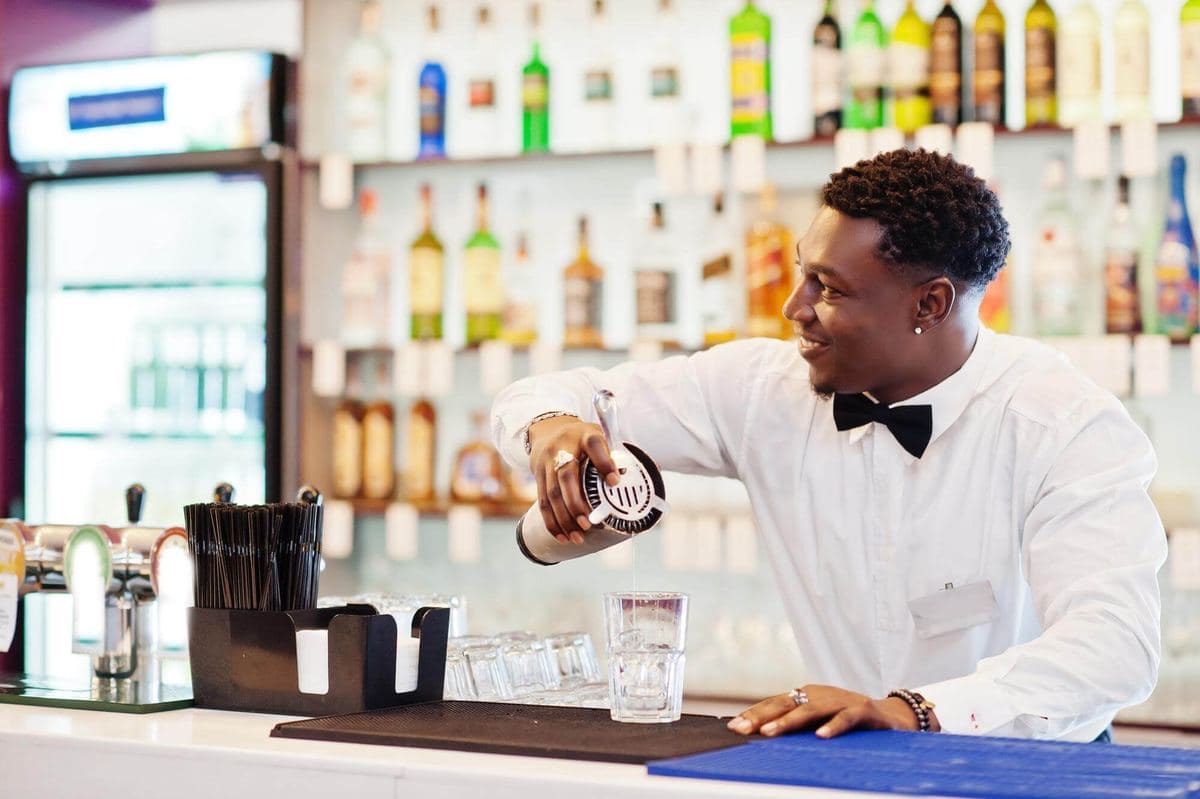 Bartender mixing a drink in front of Staycold back-bar coolers