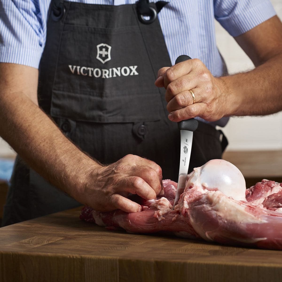 Butcher boning meat with a Victorinox knife